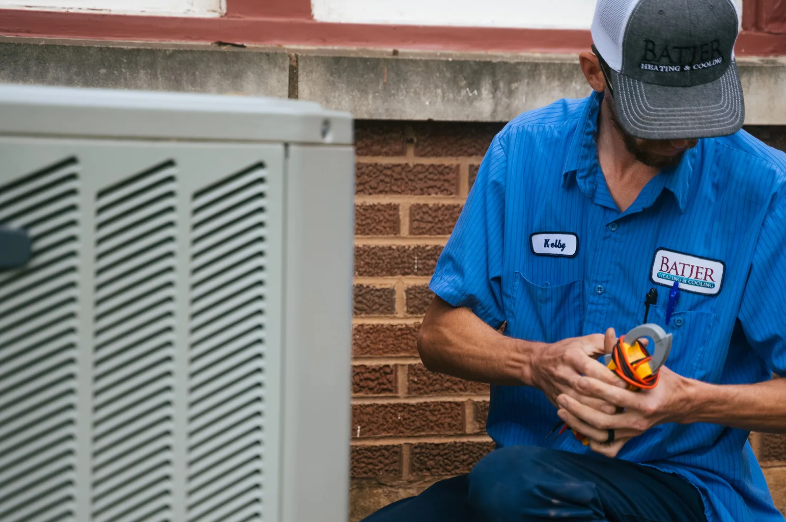 Batjer technician in a company shirt working at an outdoor unit