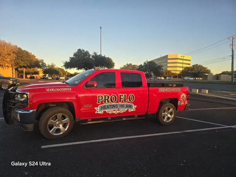 Red Pro Flo Heating & Air pickup truck in a parking lot