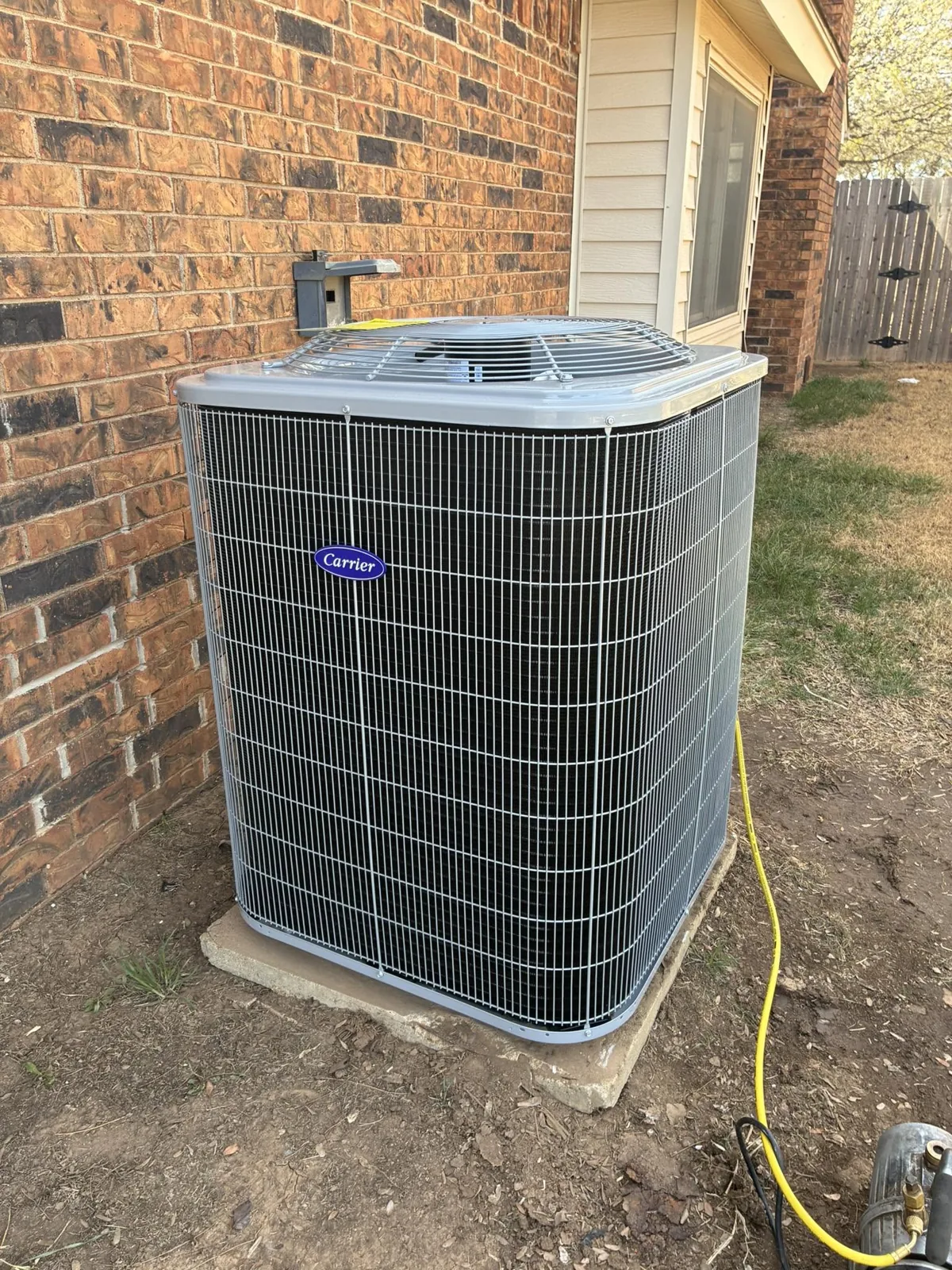 Newly installed Carrier condenser beside an Amarillo home