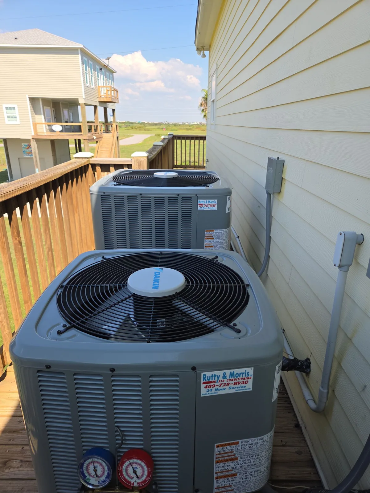 Outdoor units installed by Rutty HVAC beside a raised house