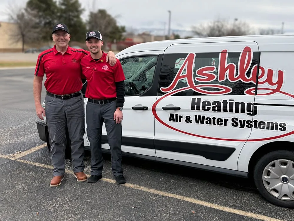 Toby and Canyon Ashley beside an Ashley Heating service van