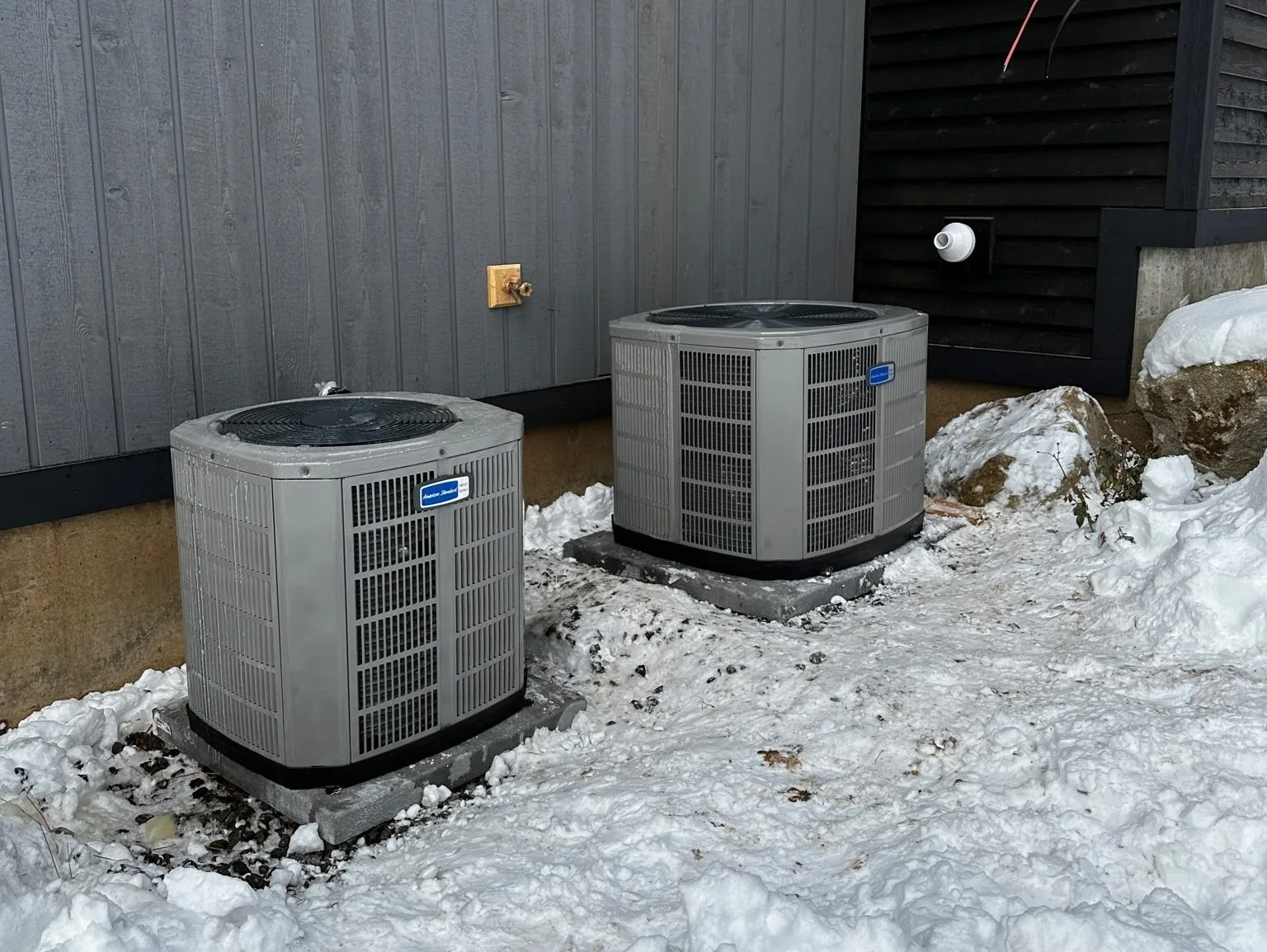 Two outdoor air conditioning units at a Boise Valley Heating & Air job in winter