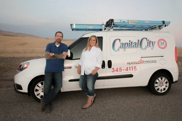 Capital City Heating & Cooling owners beside a branded service van