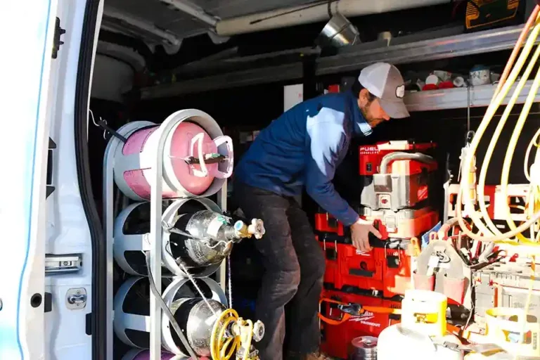 Express Plumbing Heating & Air technician taking tools from a service van for an AC installation