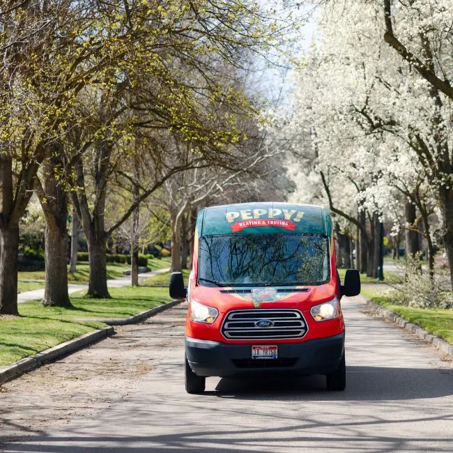Peppy Heating & Cooling service van on a tree-lined Boise street