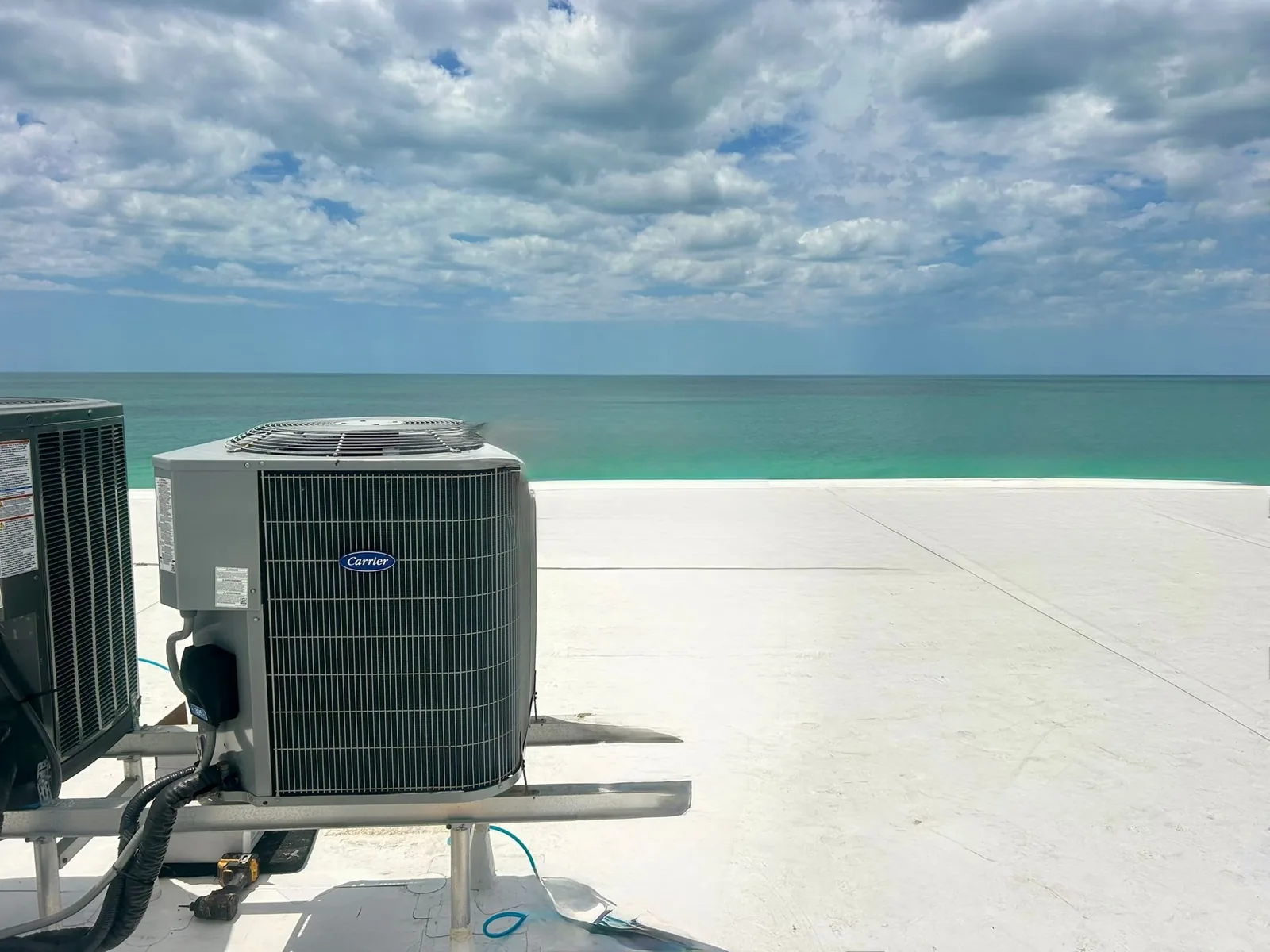 Newly set condensing units on a beachfront rooftop