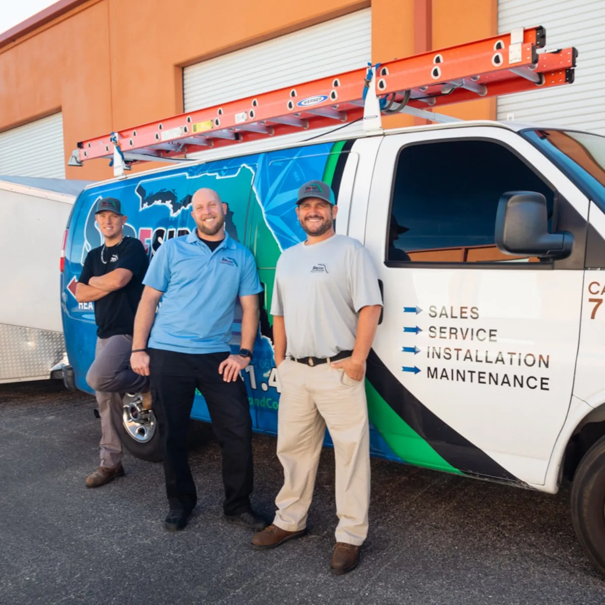 Three Surfside Heating and Cooling staff beside a company service van