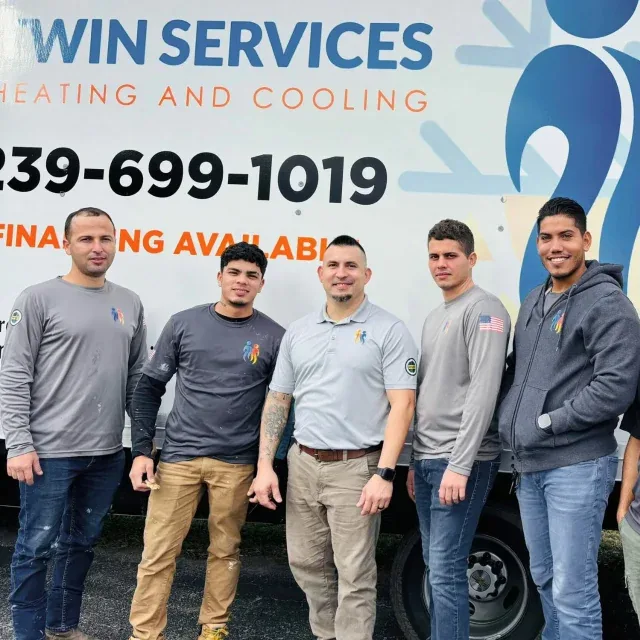 Twin Services Heating & Cooling team in front of a branded company van