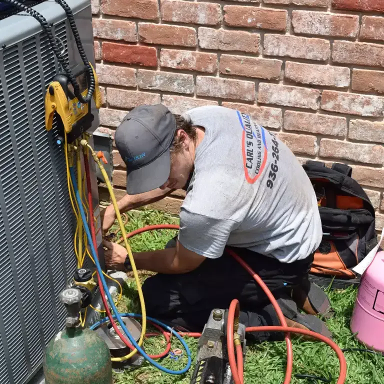 Carl's Quality Cooling technician charging a newly installed condenser