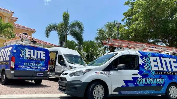 Two Elite Air Cooling service vans parked outside a building