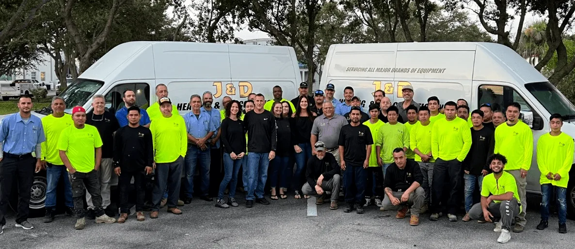 J&D Heating and Air Conditioning staff in front of company vans
