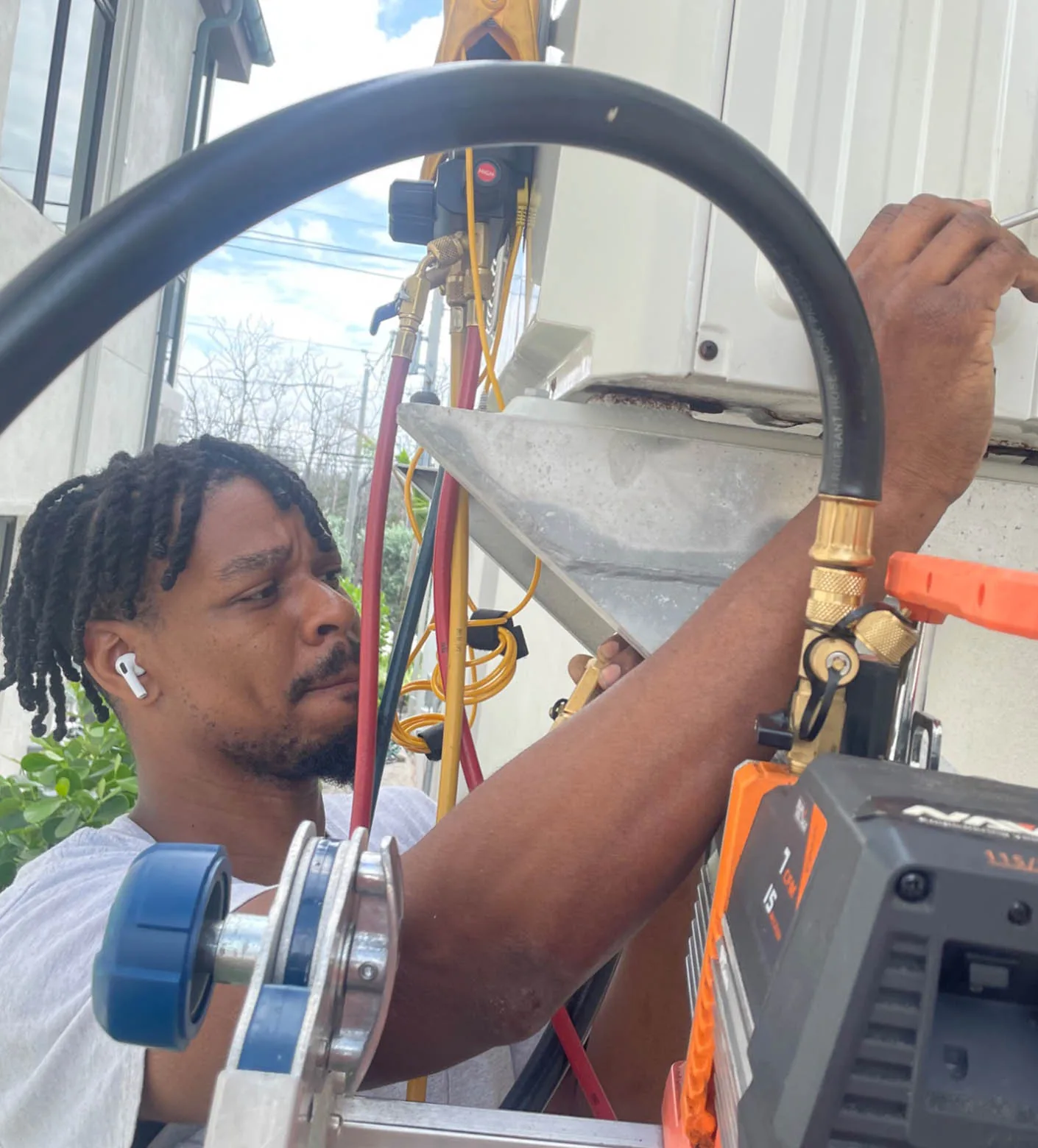 Mabry Brothers technician connecting refrigerant gauges to an air conditioning unit