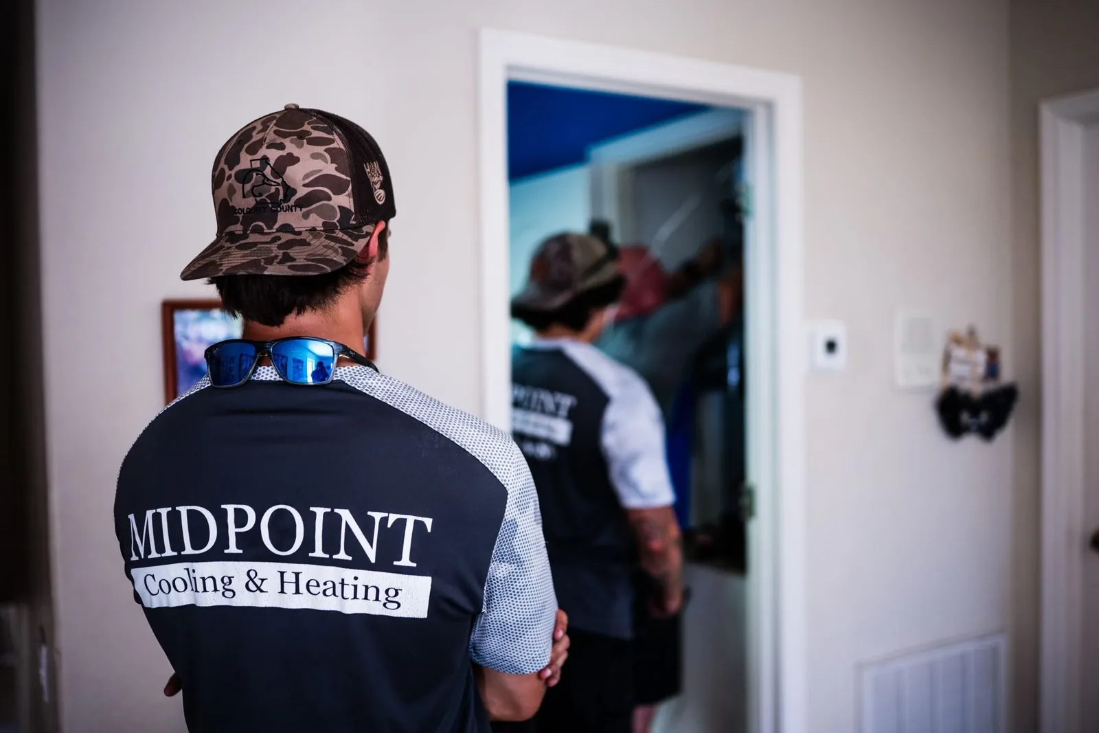 Midpoint Cooling & Heating technicians entering a home for a service call