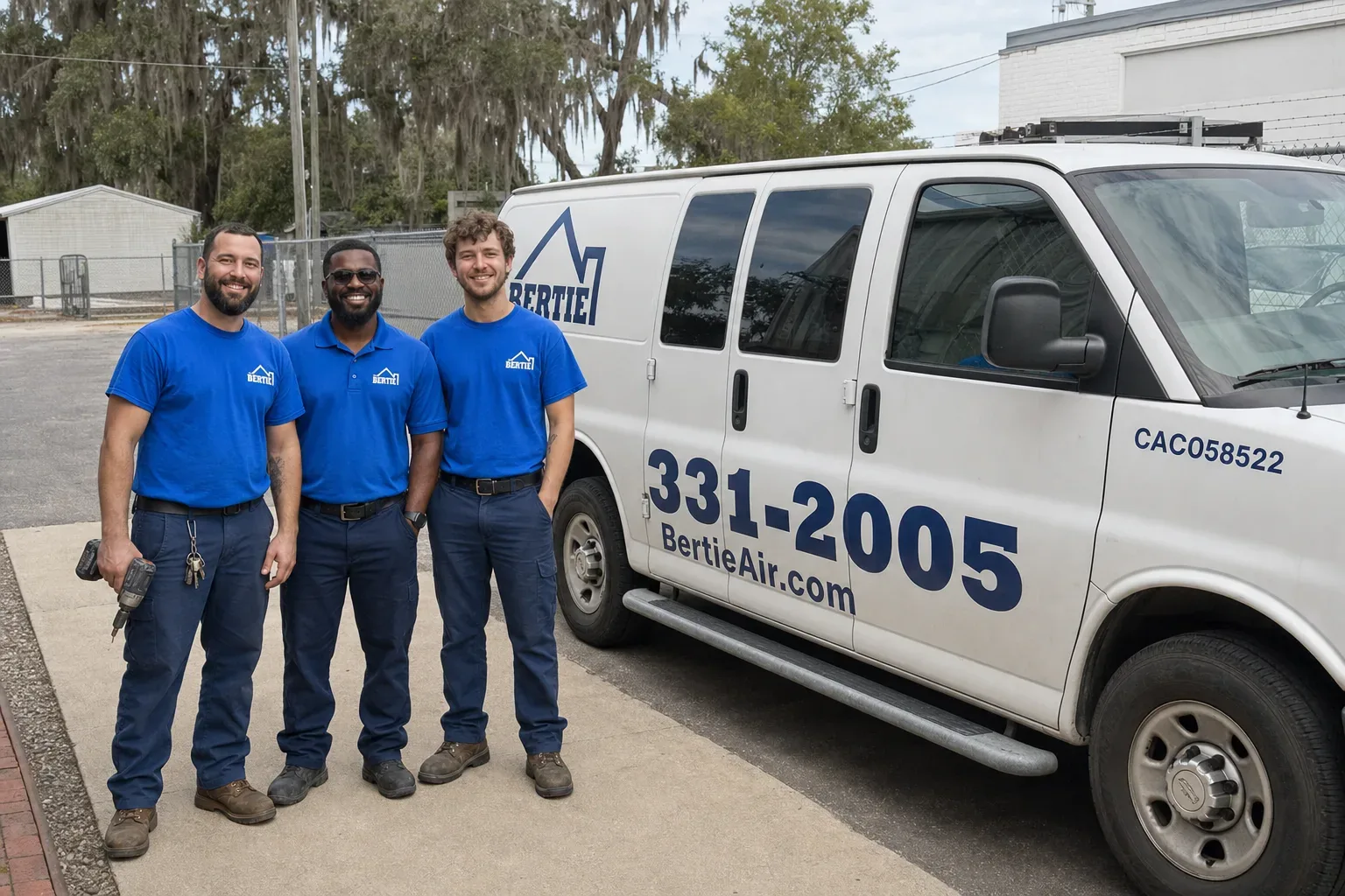 Three Bertie Air technicians standing beside a company service van