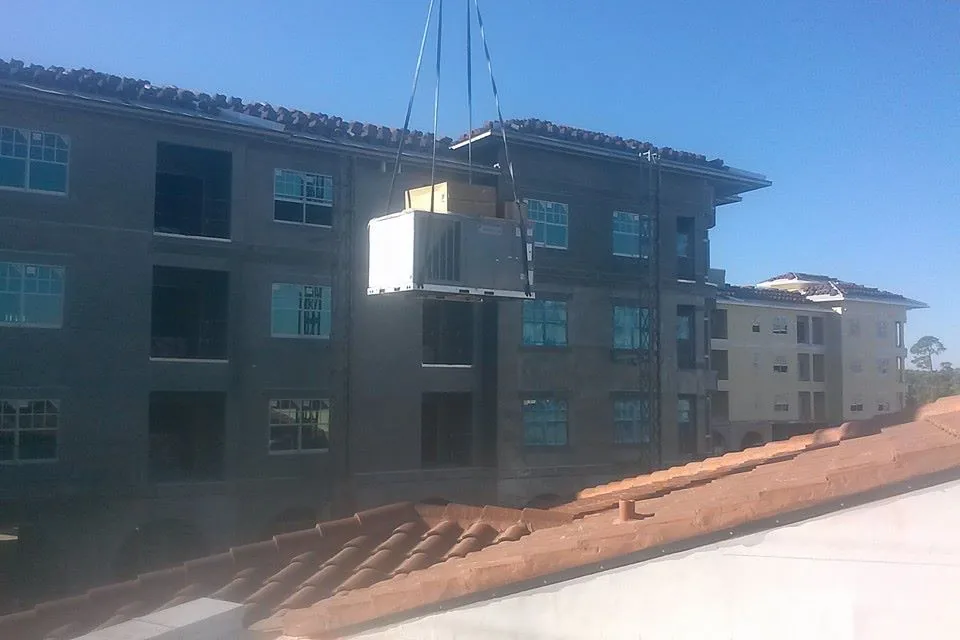 Rooftop HVAC unit being craned onto a multi-family building on a Builder's Air project