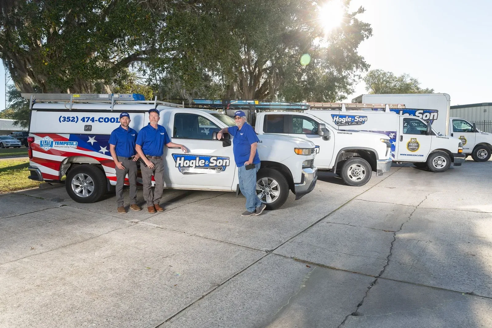 Hogle & Son team standing beside the company trucks