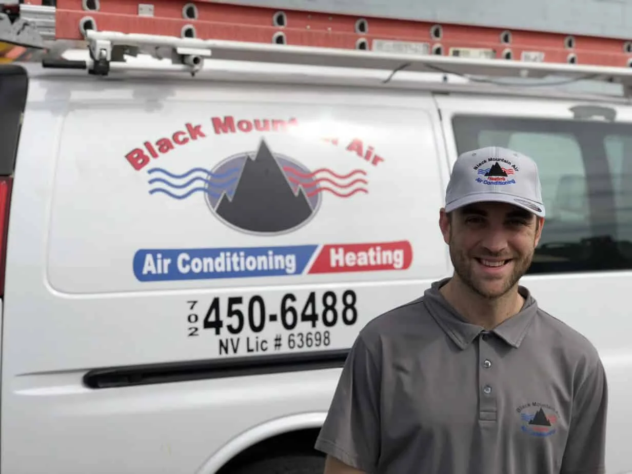 Black Mountain Air technician in front of a company van