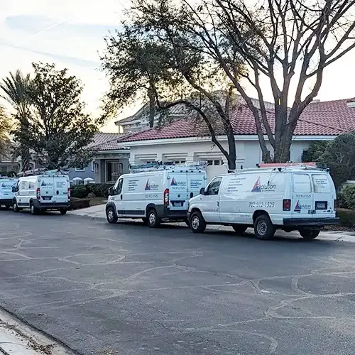 Evolution Air Conditioning vans parked on a residential street
