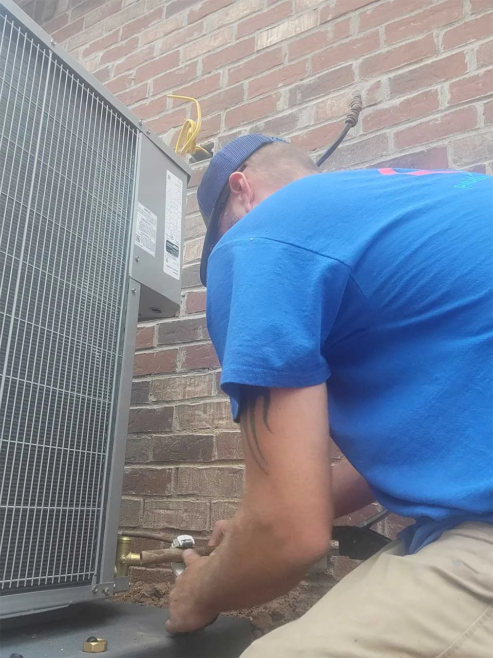 A Reid's technician working on an outdoor AC unit