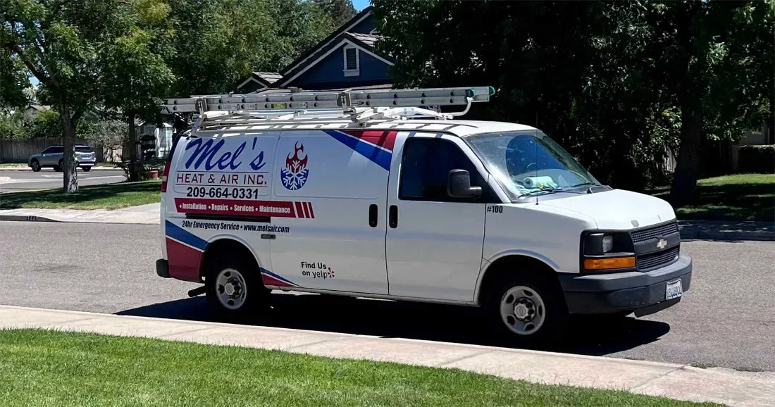 Mel's Heat & Air service van parked on a residential street