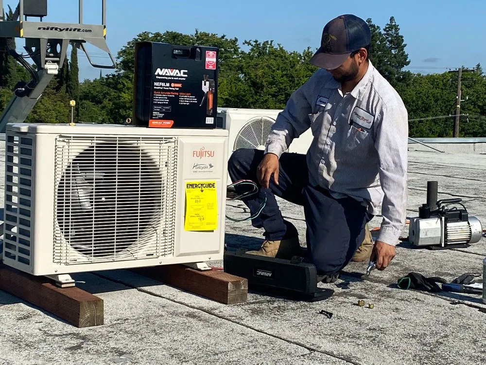 Thorsen's-Norquist technician installing a ductless mini-split condenser on a roof