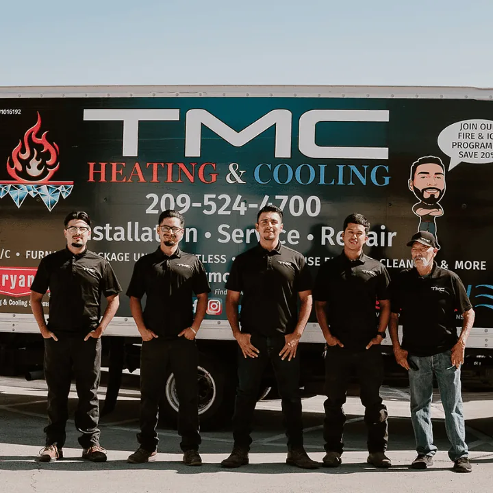TMC Heating & Cooling crew in front of a company-branded truck