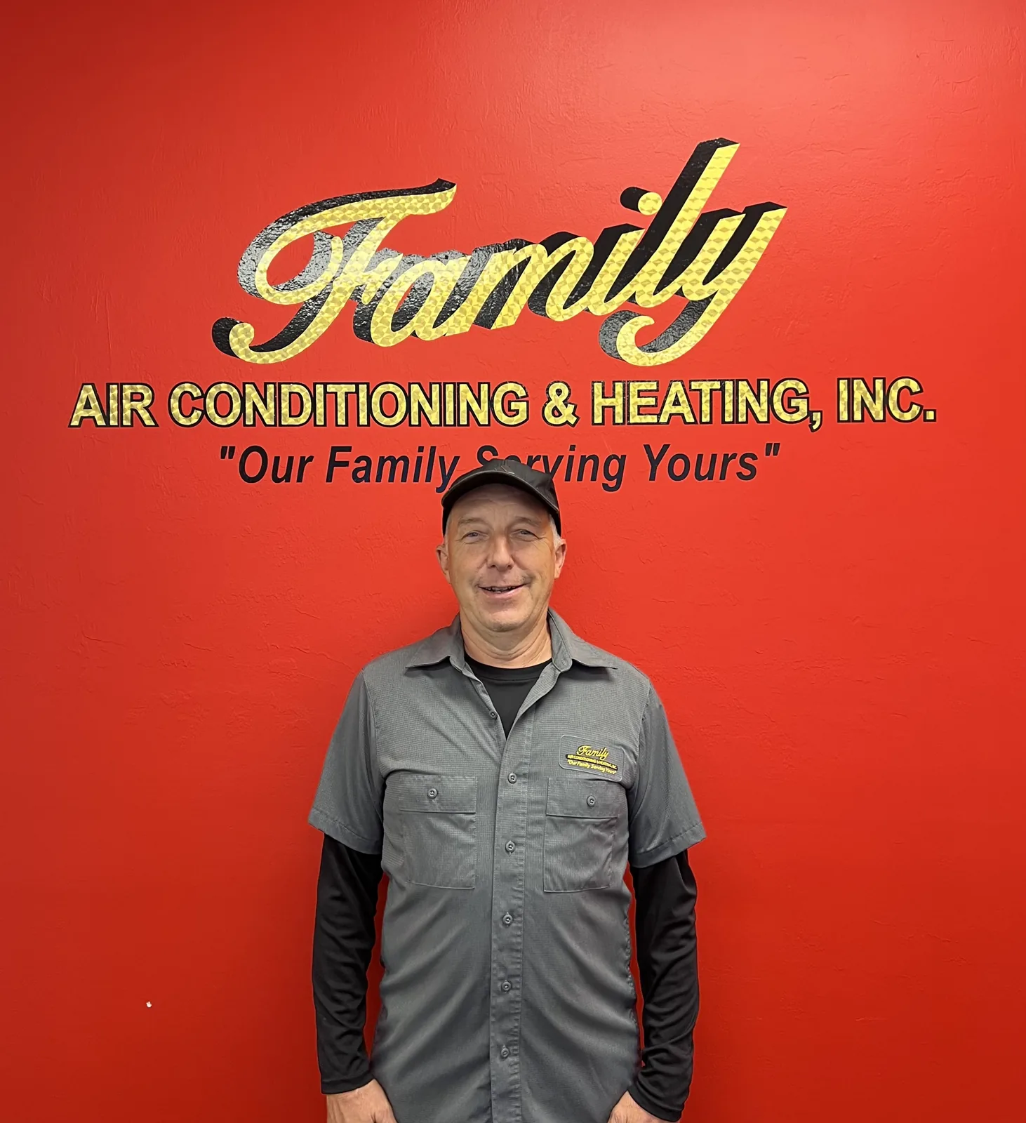 Family Air Conditioning & Heating team member in front of the company sign