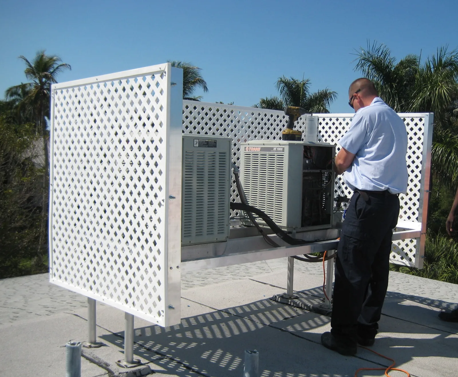 Johnson's Air Conditioning technician servicing a rooftop condensing unit