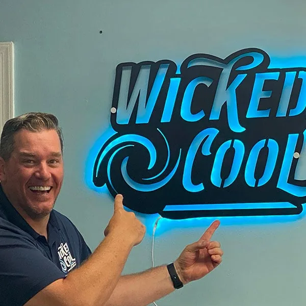 Wicked Cool president Andy Elwell beside the company sign at its office