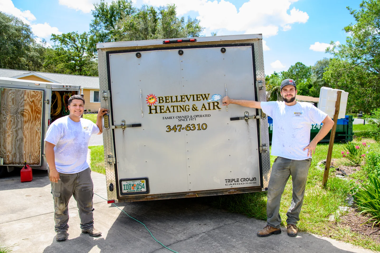 Two Belleview Heating & Air technicians beside the company trailer