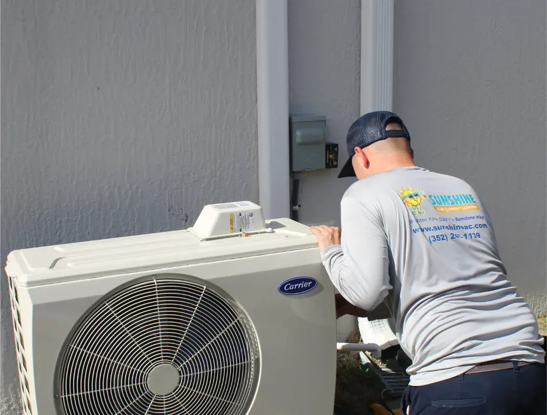 Sunshine Air Conditioning technician working on a Carrier outdoor unit