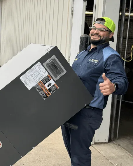 Mega Care Solutions technician carrying a new indoor HVAC unit