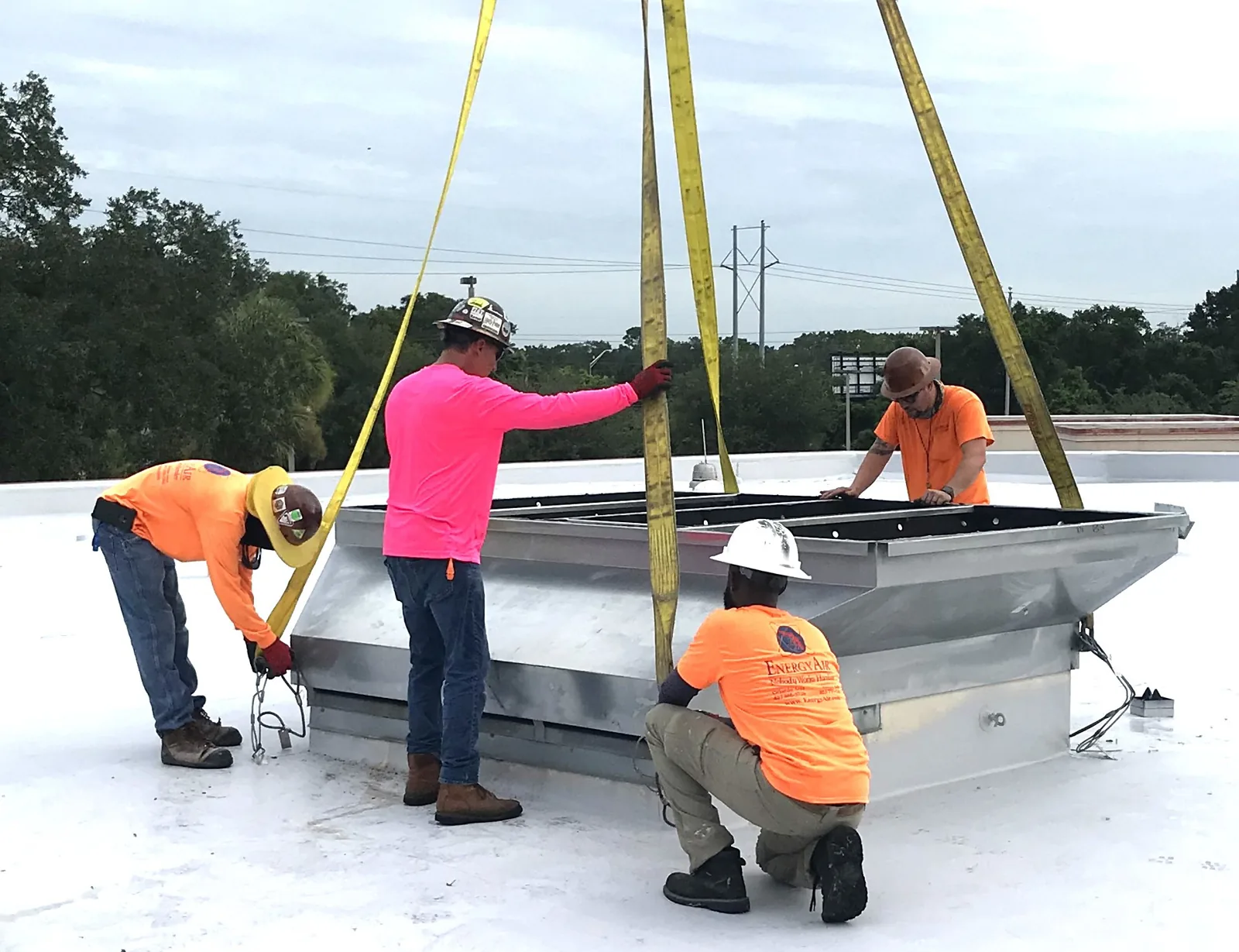 Energy Air crew setting a rooftop unit curb by crane