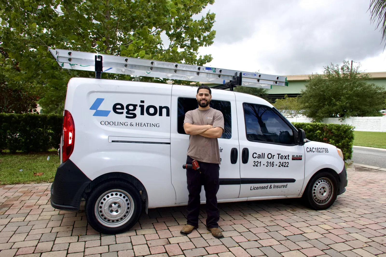 Legion Cooling & Heating technician beside the company van