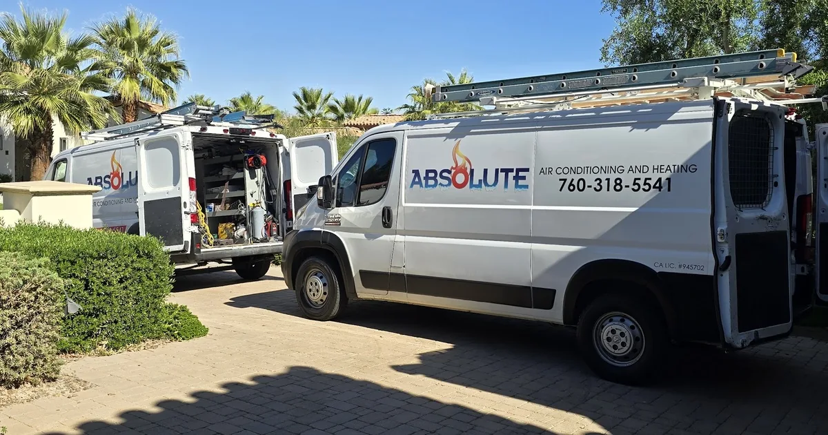 Two Absolute Air Conditioning & Heating vans at a desert home