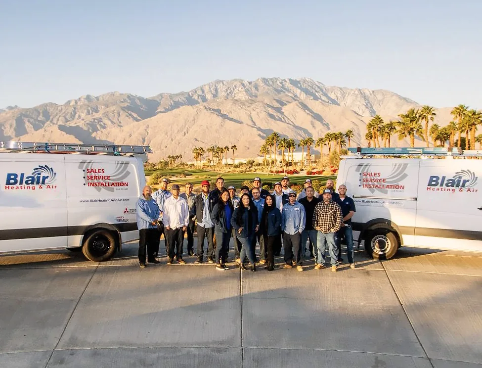 The Blair Heating & Air team between two company vans with the Santa Rosa Mountains behind