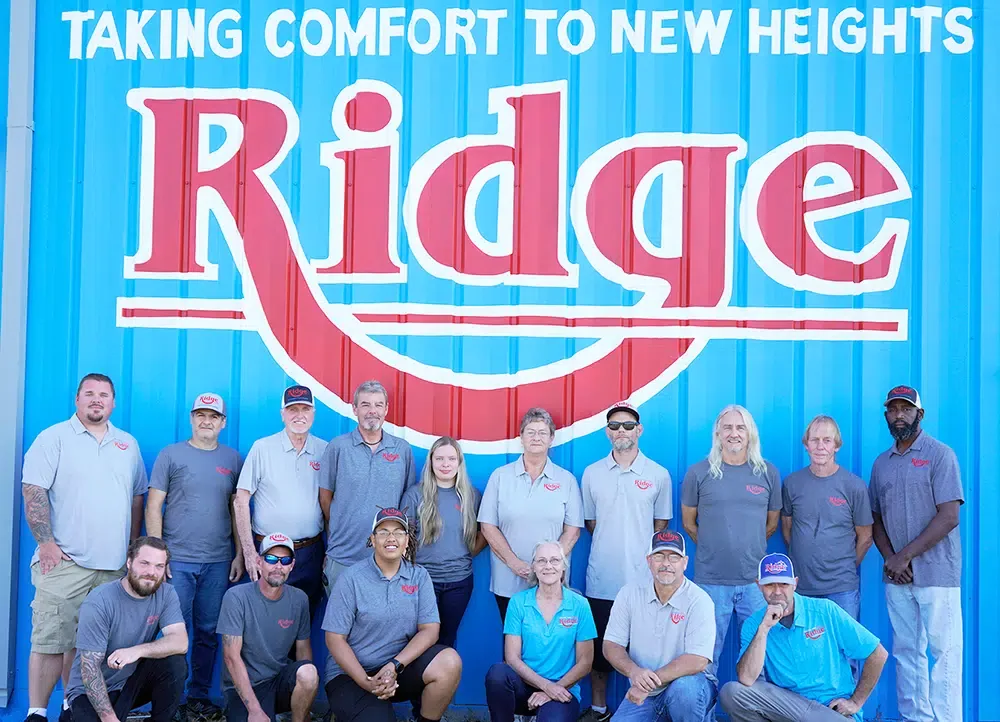 Ridge team in front of the company's painted Ridge sign