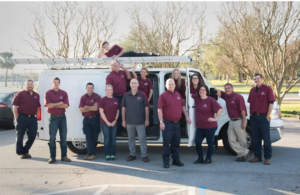 Family Heating & Air staff in company shirts beside a service van