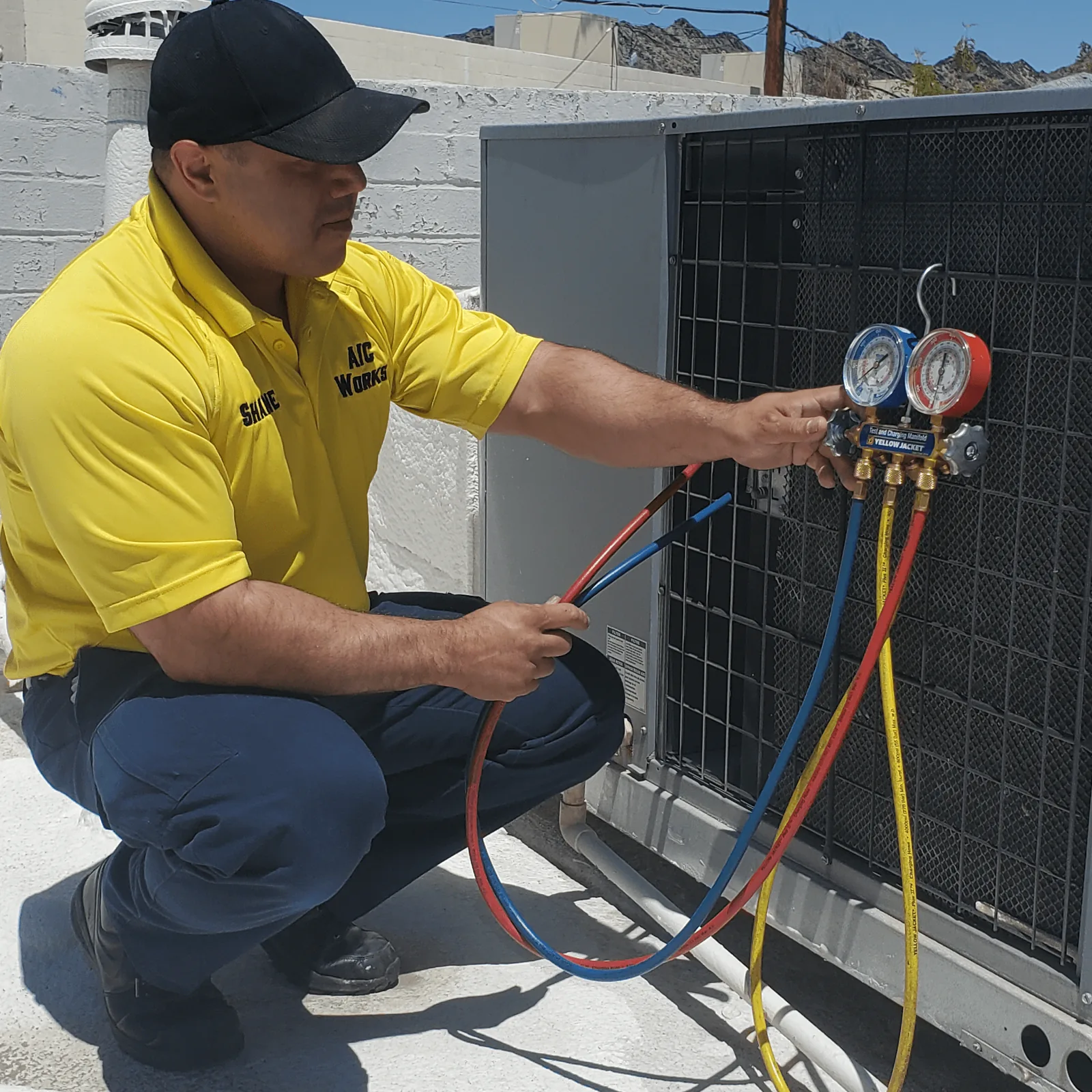 AC Works owner checking refrigerant pressures on a condenser