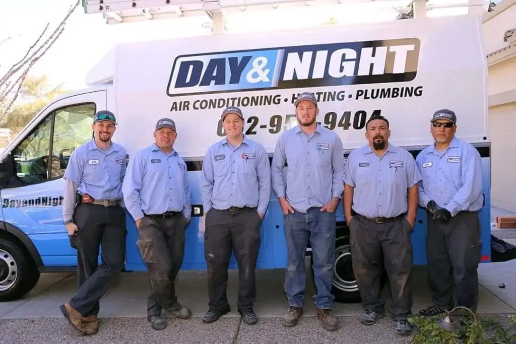 Day & Night technicians in front of a company van