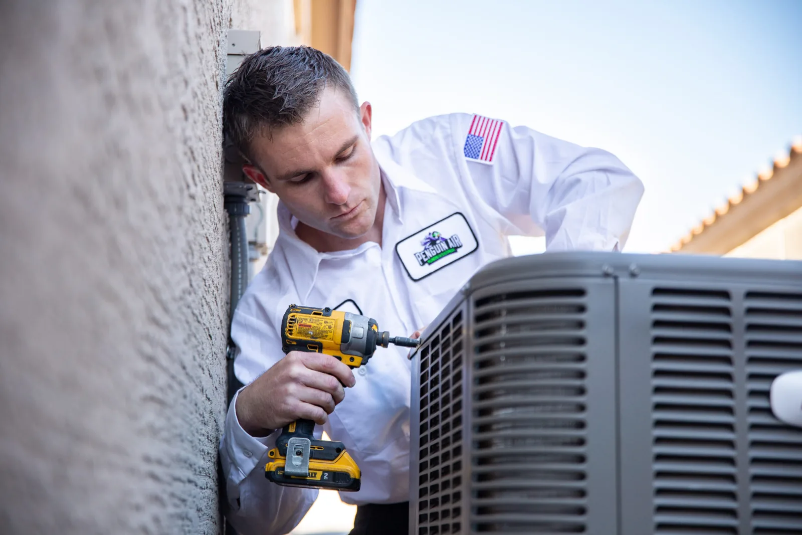 Penguin Air technician working on an outdoor air conditioning unit
