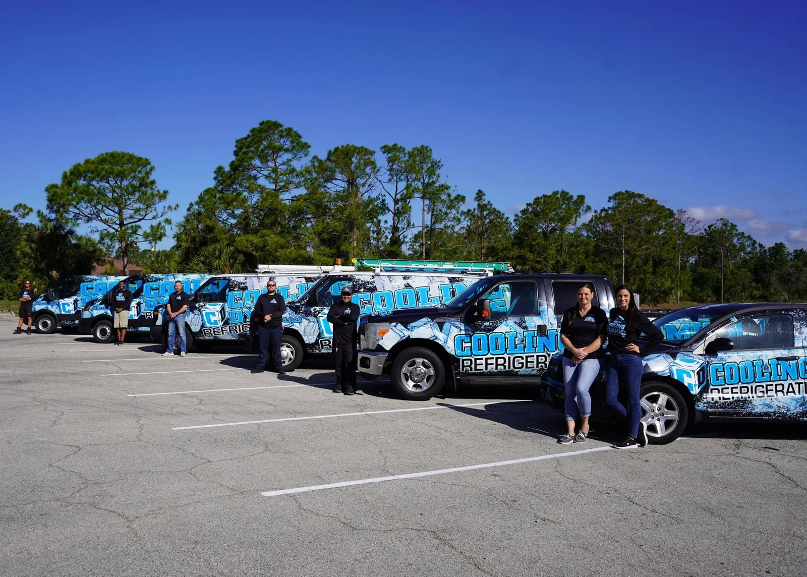 Cooling Dynamics staff with the company's fleet of wrapped trucks