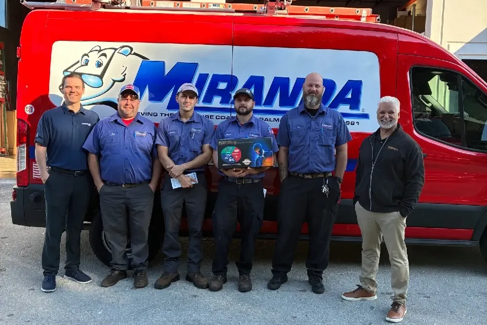Miranda Plumbing & Air Conditioning team in front of a company van