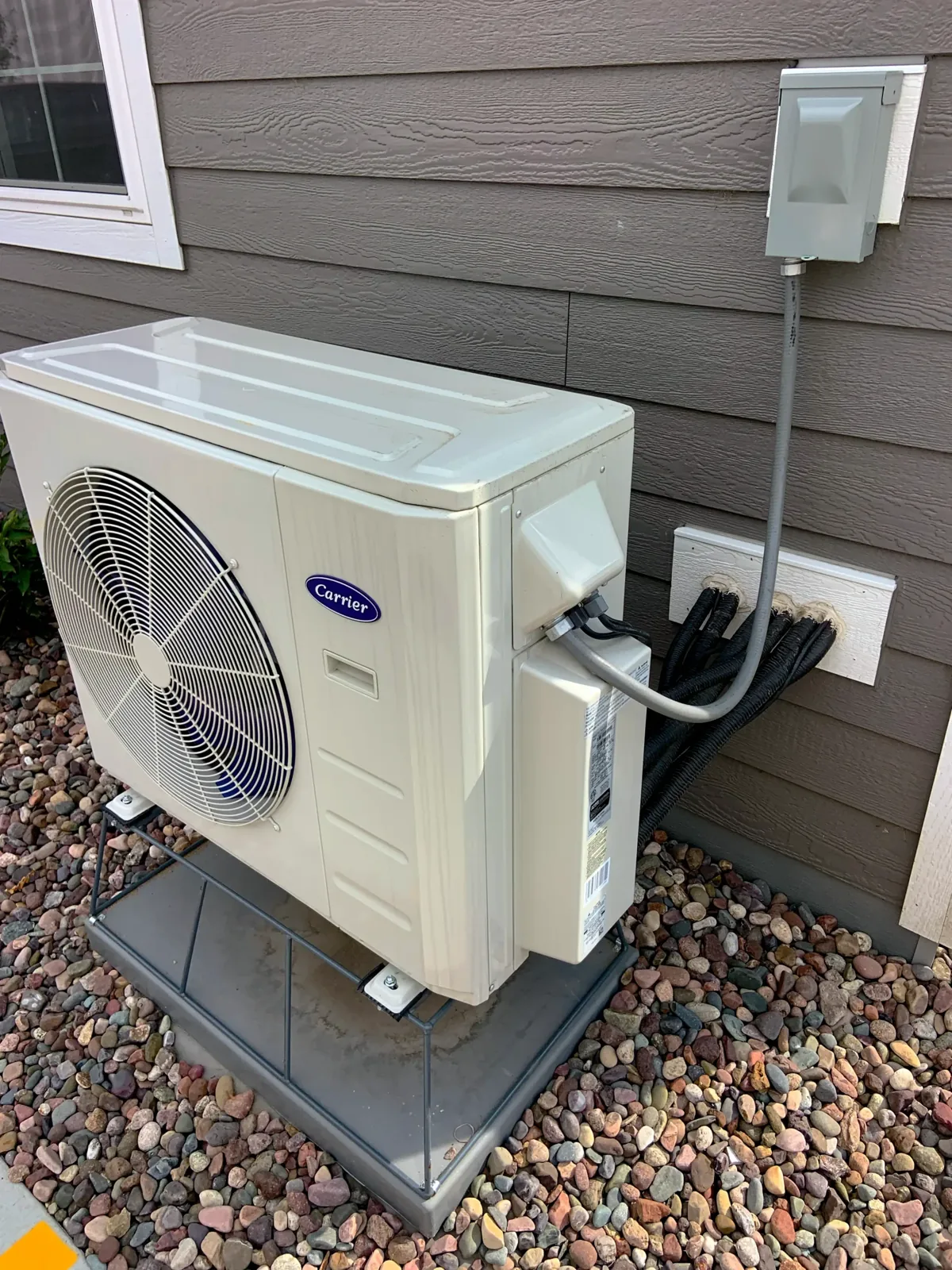 Outdoor heat pump unit on a pad beside a house, from the Balanced Heating & Air website