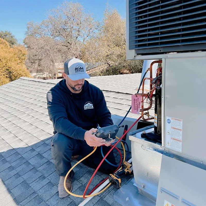 Shasta Heating & Air technician diagnosing a rooftop package unit