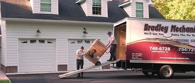 Bradley Mechanical technicians unloading a new heat pump from a company truck