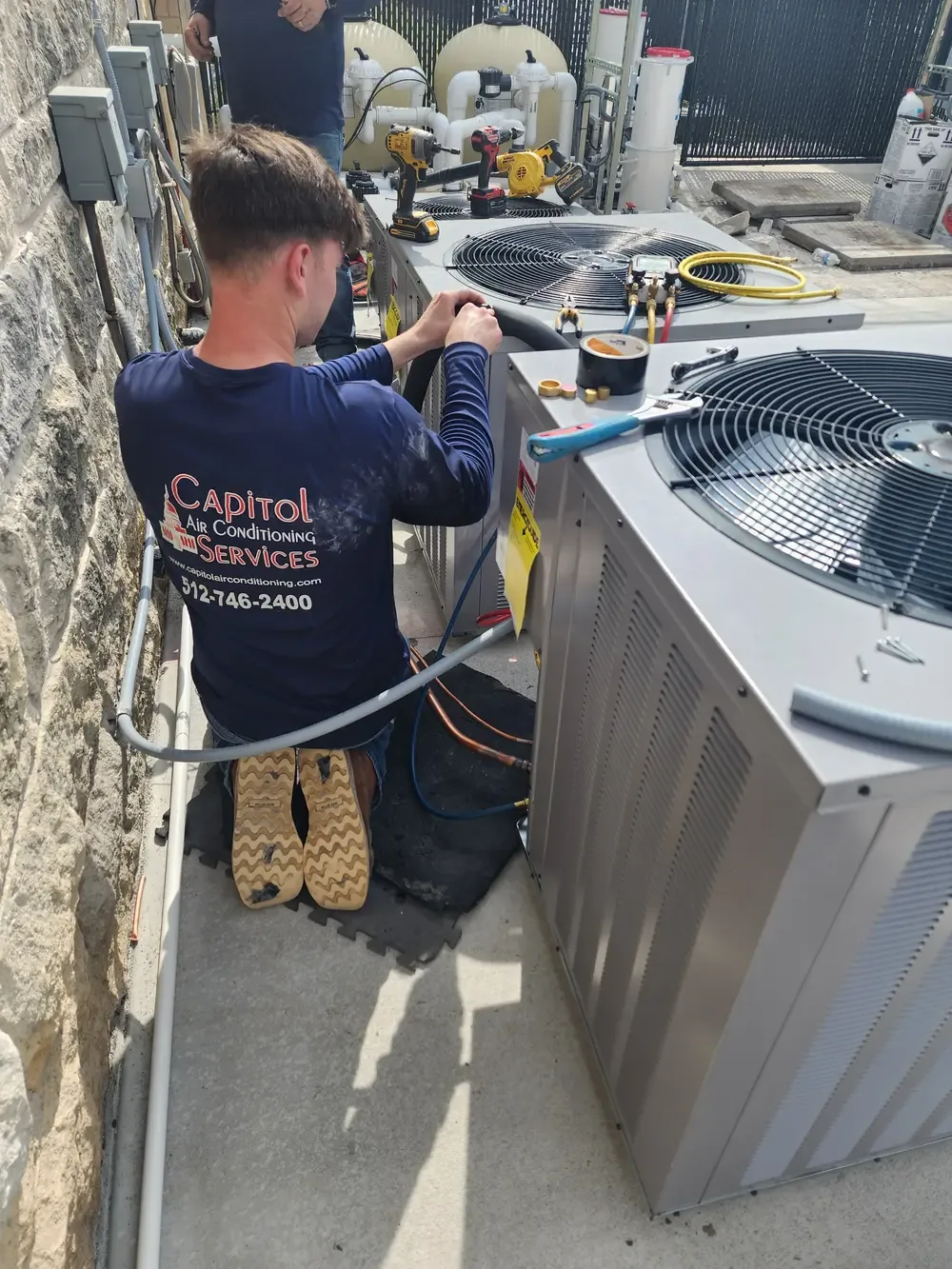Capitol Air Conditioning Services technician working on an outdoor unit
