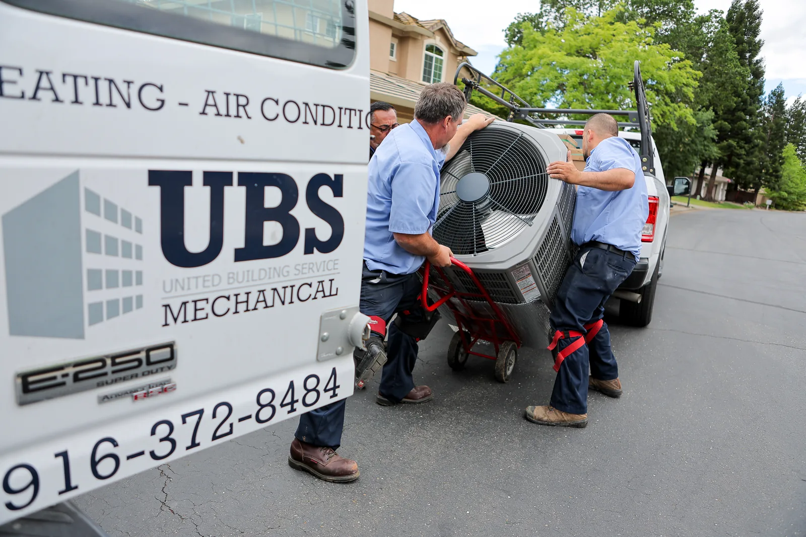 UBS Mechanical technicians unloading an outdoor unit from a company truck