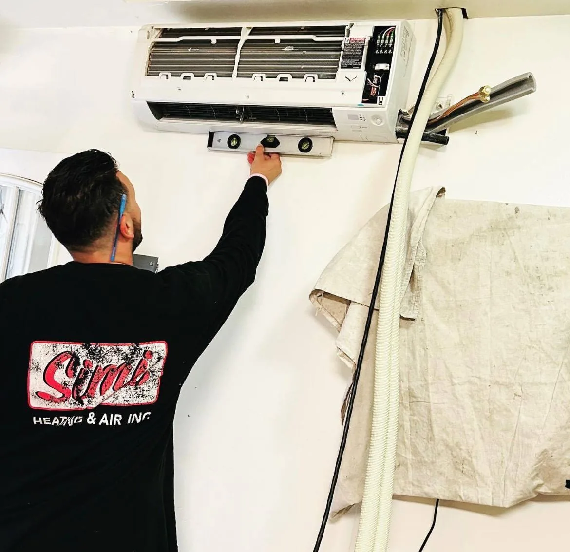 Simi Heating & Air technician working on a wall-mounted mini-split unit