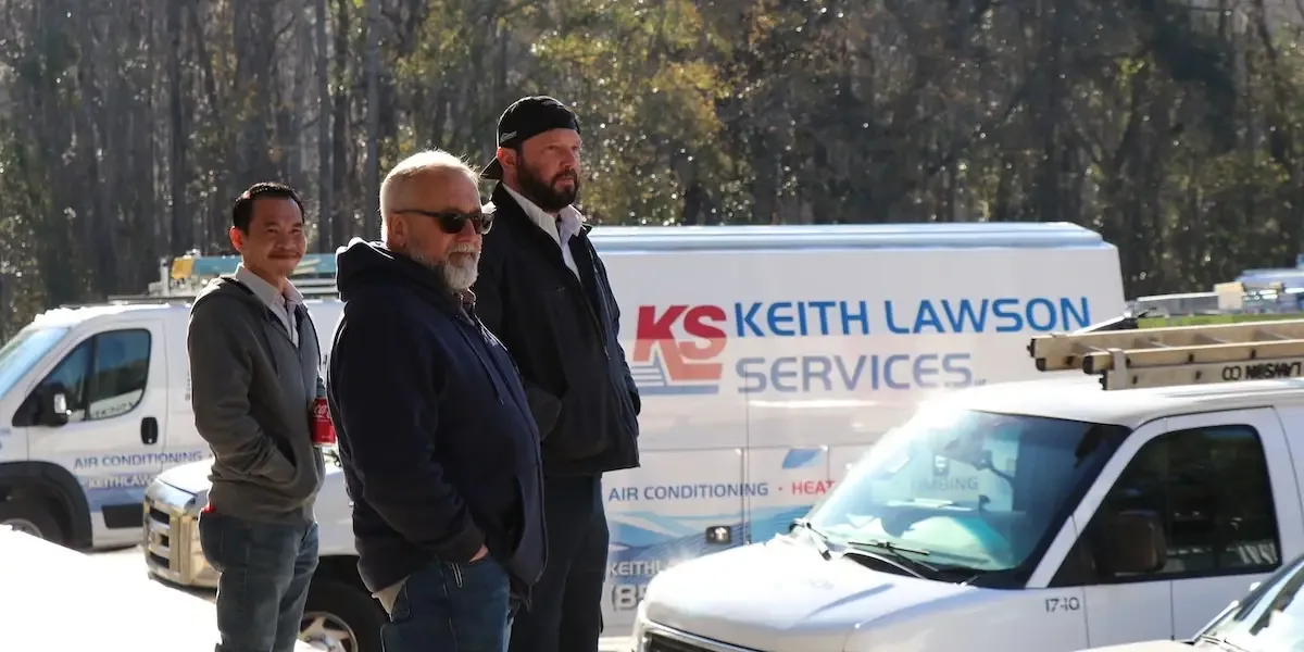 Three Keith Lawson Services staff in front of a branded service van